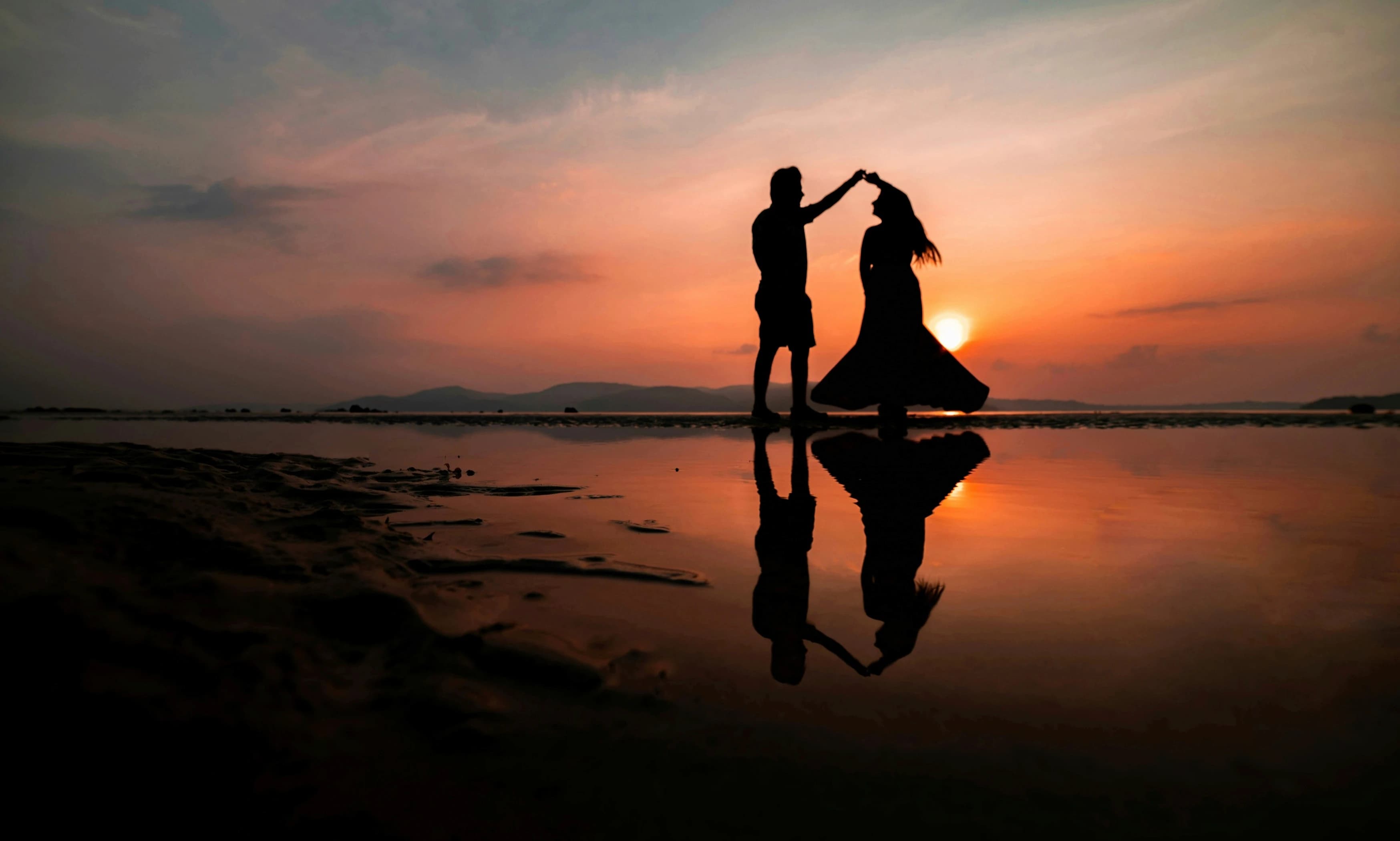 dança de casal na praia ao pôr do sol